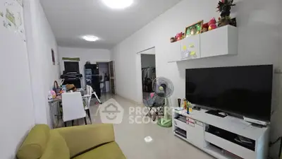 Spacious living room with modern decor and entertainment setup in a cozy apartment.