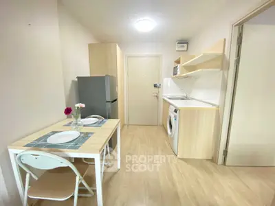 Cozy kitchen with dining area, featuring modern appliances and light wood finishes, perfect for compact living.