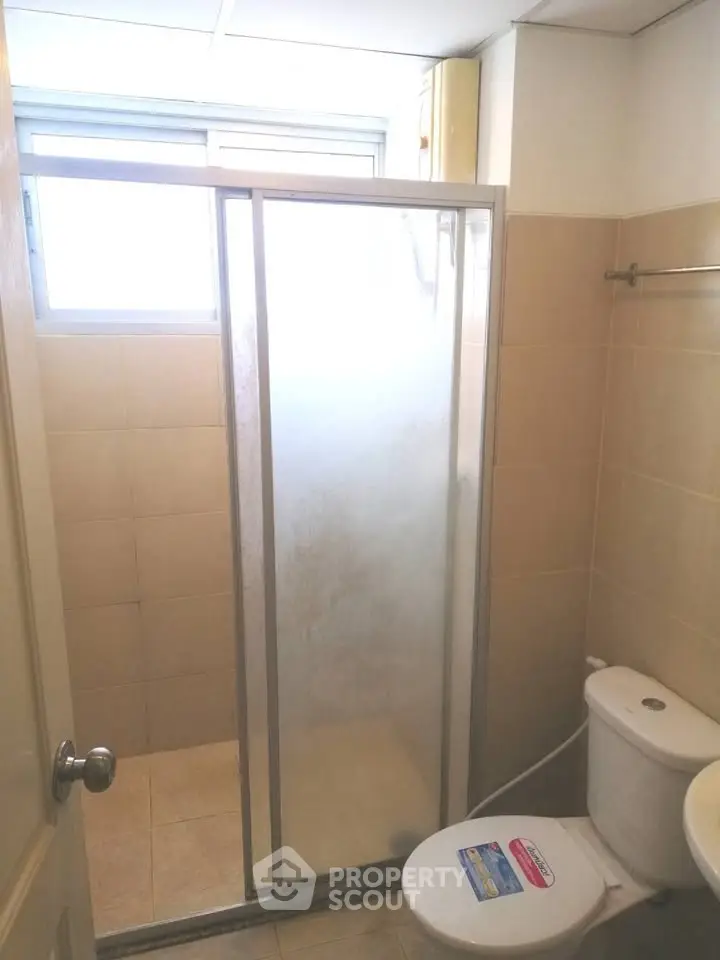 Compact bathroom with shower enclosure and toilet in a modern apartment.