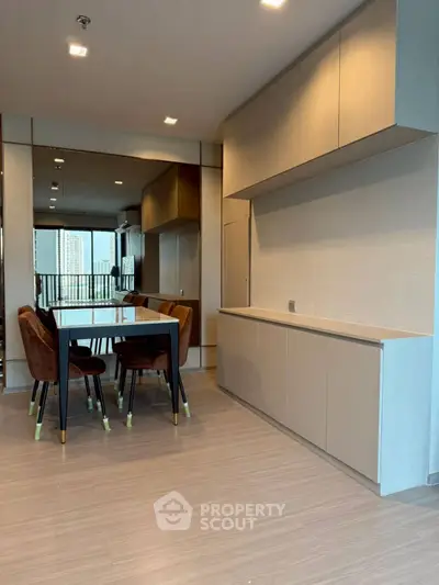 Modern dining area with sleek cabinetry and city view balcony