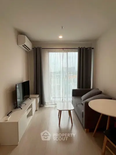 Modern living room with natural light, featuring a cozy sofa, TV, and dining area, perfect for urban living.