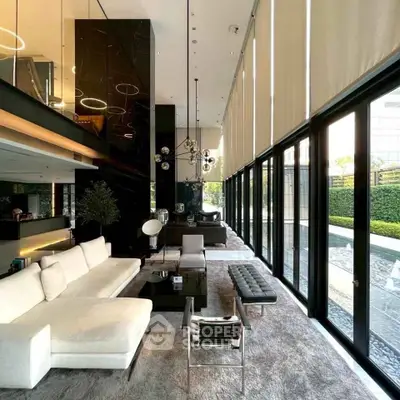 Luxurious modern living room with floor-to-ceiling windows and elegant furnishings.
