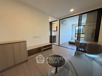 Modern apartment interior with open layout, featuring sleek furniture and natural light.