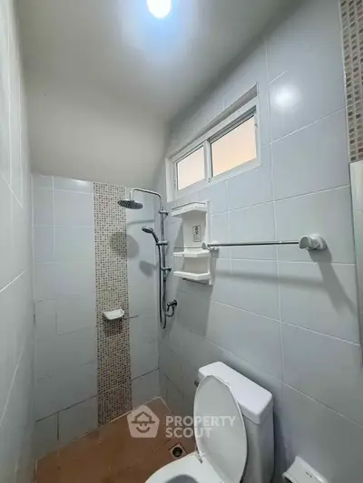 Modern bathroom with sleek shower and tiled walls in a compact space.