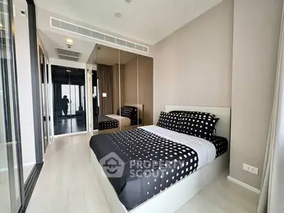 Modern bedroom with stylish decor and mirrored closet doors in a contemporary apartment.