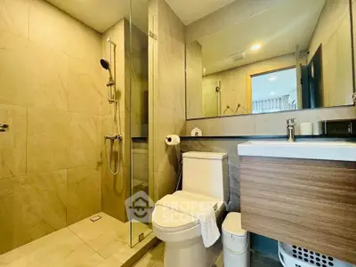 Modern bathroom with glass shower and sleek fixtures in contemporary home.
