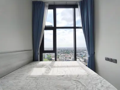 High-rise bedroom with stunning city view through large window