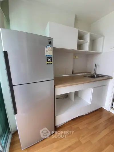 Modern kitchen with sleek stainless steel fridge and minimalist cabinetry
