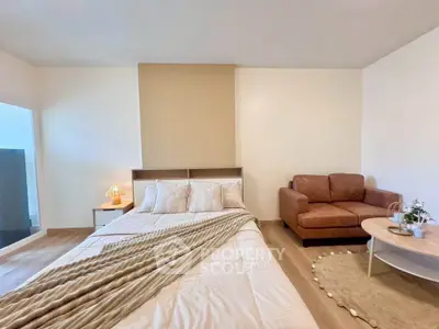 Spacious bedroom with cozy seating area and modern decor
