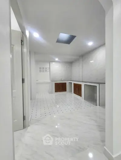 Spacious modern kitchen with sleek marble flooring and ample cabinetry