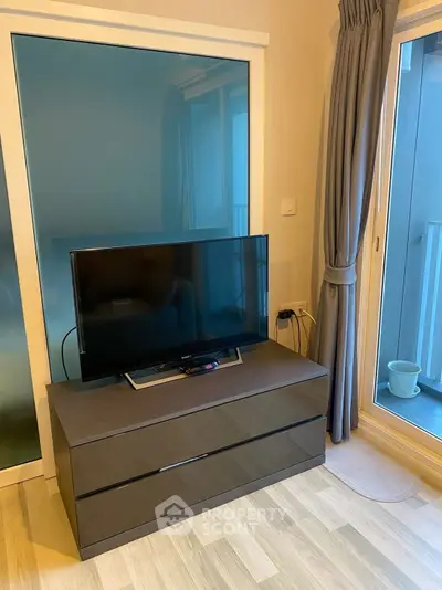 Modern living room with sleek TV stand and large window view.