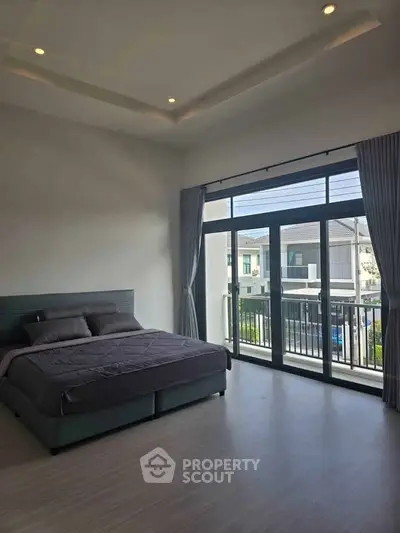 Spacious bedroom with large windows and balcony access in modern home