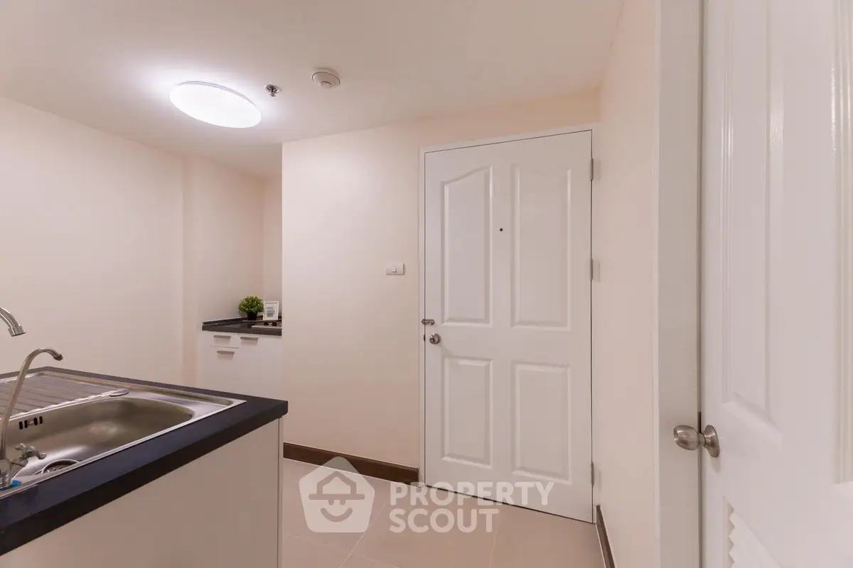 Modern apartment entrance with sleek kitchen sink and minimalist decor