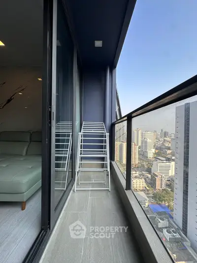 Modern high-rise balcony with stunning city view and sleek glass railing.
