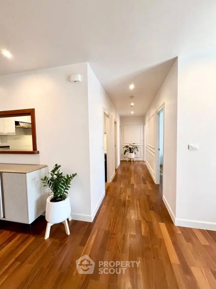 Spacious hallway with wooden flooring and modern decor in a stylish home.