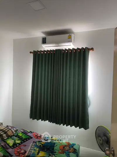 Cozy bedroom with air conditioning and dark green curtains, perfect for relaxation.