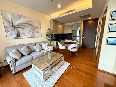 Modern living room with elegant decor and open kitchen layout in a stylish apartment.