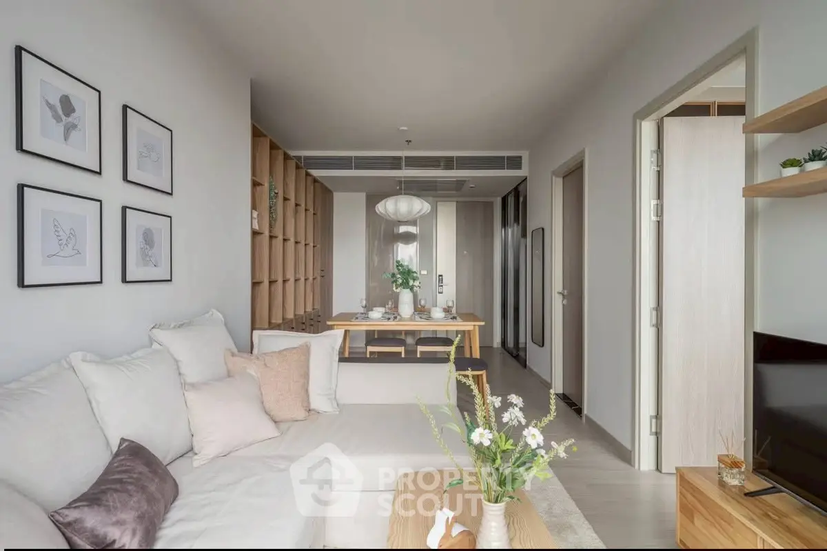 Modern living room with cozy sofa and elegant dining area in open-plan apartment.