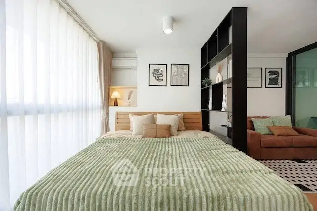 Modern bedroom with stylish decor and cozy ambiance, featuring a plush bed and elegant shelving.