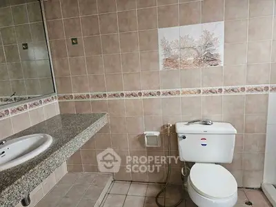Spacious bathroom with tiled walls and modern fixtures