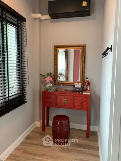 Charming corner with red console table and mirror in cozy home interior