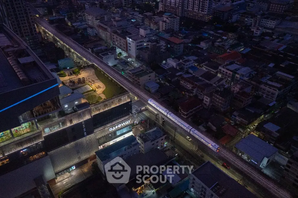 Stunning aerial view of urban landscape with illuminated buildings and bustling city life at night.