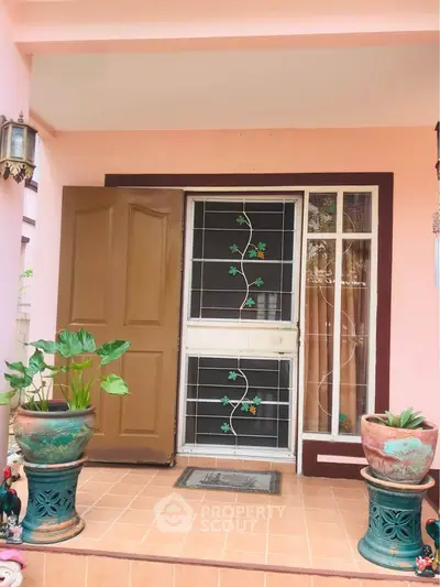 Charming entrance with decorative plants and unique door design, perfect for welcoming guests.
