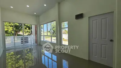 Spacious modern living room with large windows and glossy floors