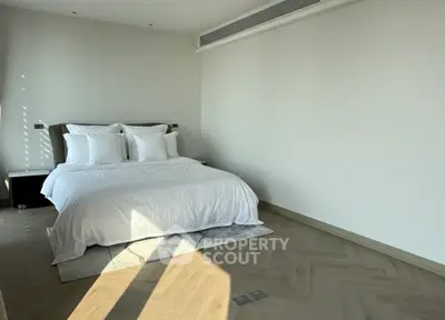 Spacious modern bedroom with elegant design and natural light, featuring a cozy bed and stylish flooring.