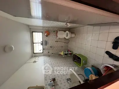 Cozy bathroom with tiled walls and floor, featuring a bathtub and window for natural light.