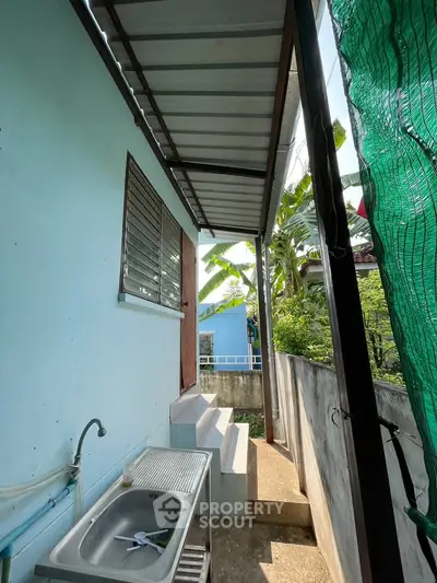 Charming exterior view with outdoor sink and steps leading to a cozy home entrance.