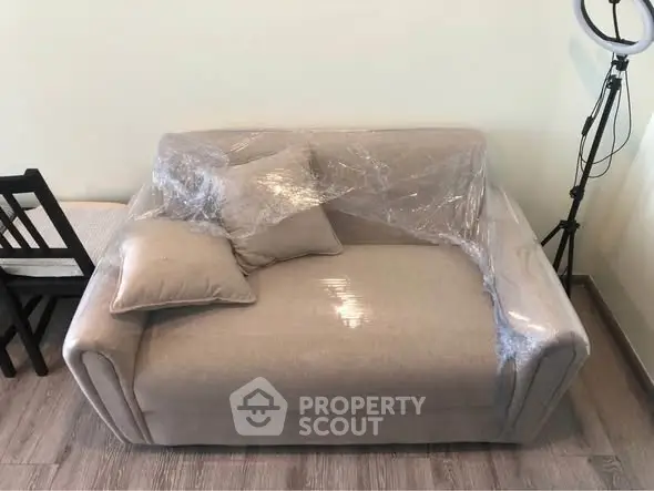 Cozy living room with a wrapped beige sofa and modern decor