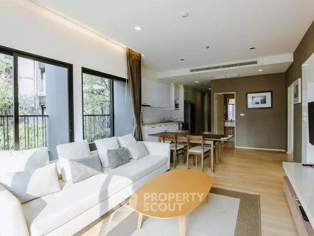 Spacious modern living room with open kitchen and natural light