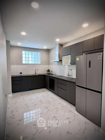 Modern kitchen with sleek cabinetry and marble flooring in a stylish apartment.