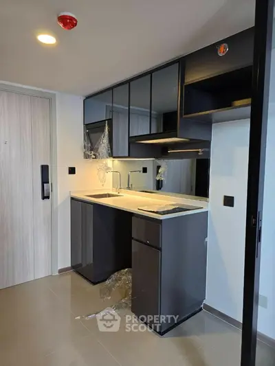 Modern compact kitchen with sleek cabinetry and integrated appliances