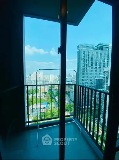 Stunning high-rise balcony view with cityscape and blue sky, perfect for urban living.