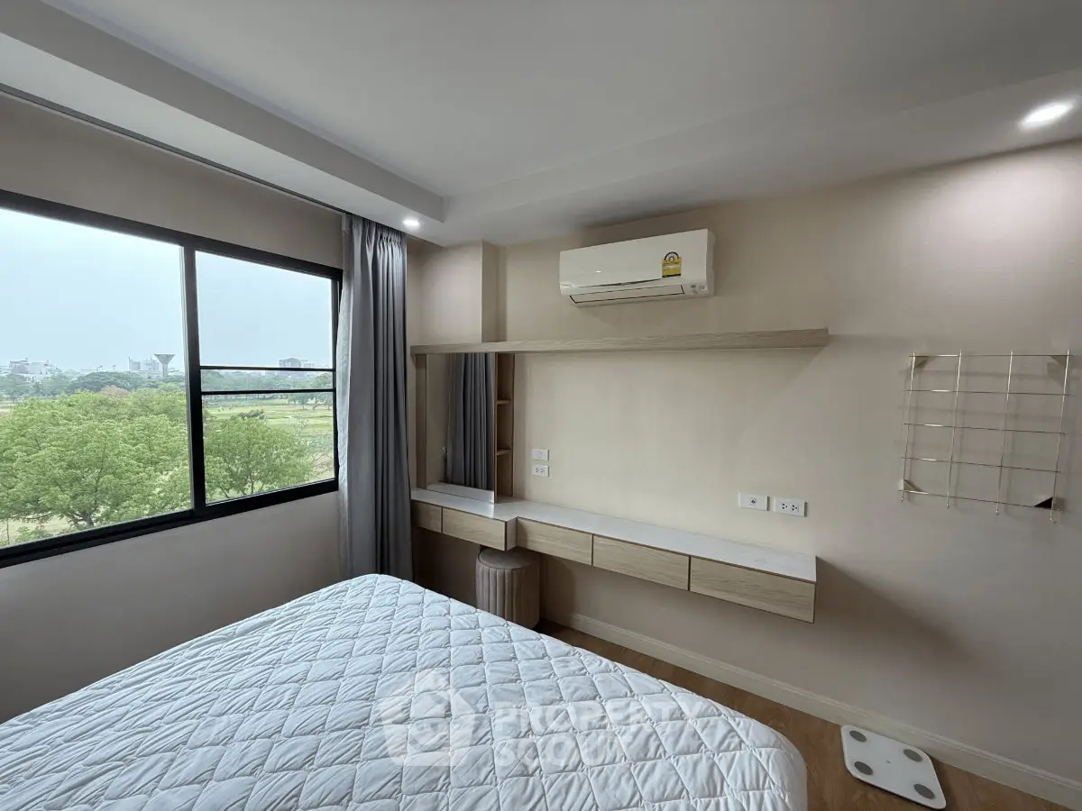 Modern bedroom with large window and air conditioning, offering a serene view of greenery.
