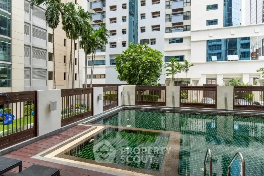 Luxurious urban apartment complex with a serene swimming pool and modern architecture.