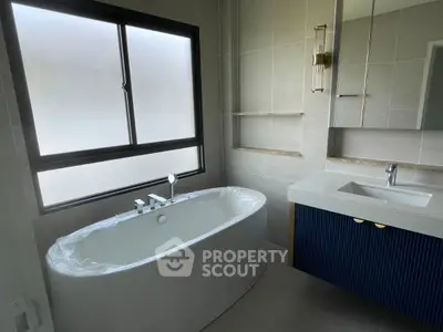 Modern bathroom with elegant bathtub and stylish vanity in a contemporary home.