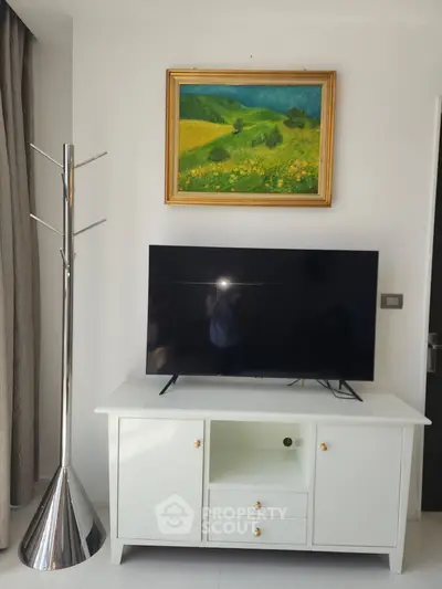 Modern living room with sleek TV stand and vibrant landscape painting, perfect for stylish home entertainment.