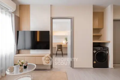 Modern living room with sleek TV, stylish decor, and adjacent study area.