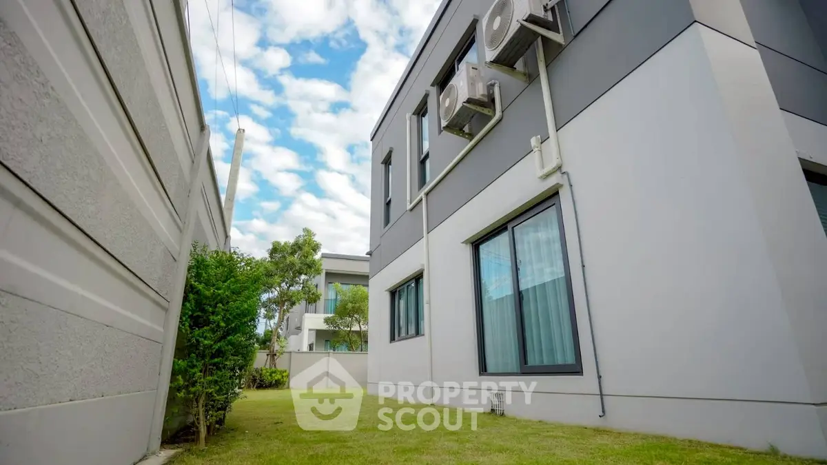 Modern building exterior with air conditioning units and lush green lawn