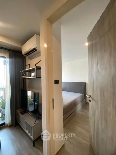 Modern apartment interior with bedroom and living area, featuring sleek design and natural light.