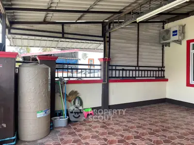 Spacious covered outdoor area with tiled flooring and storage space.