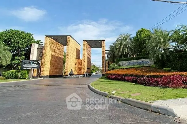 Stunning modern building entrance with lush landscaping and unique architectural design.
