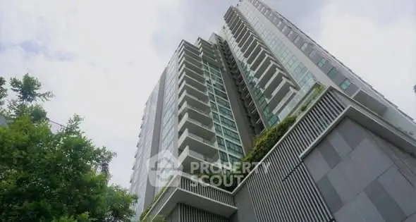 Modern high-rise building with sleek design and lush greenery, offering urban living with stunning views.
