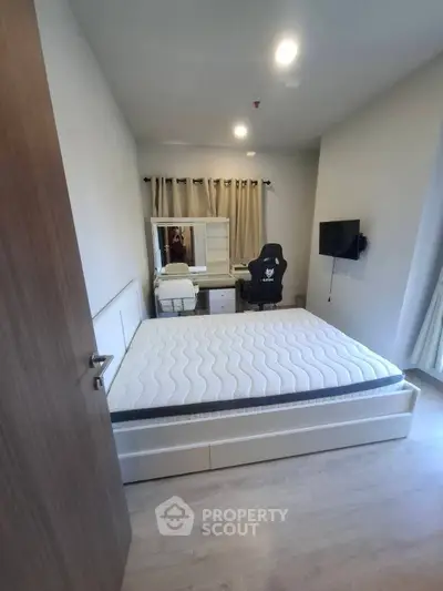 Modern bedroom with stylish furniture and gaming chair, perfect for comfort and productivity.