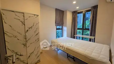 Modern bedroom with large windows and stylish wardrobe in a cozy apartment.