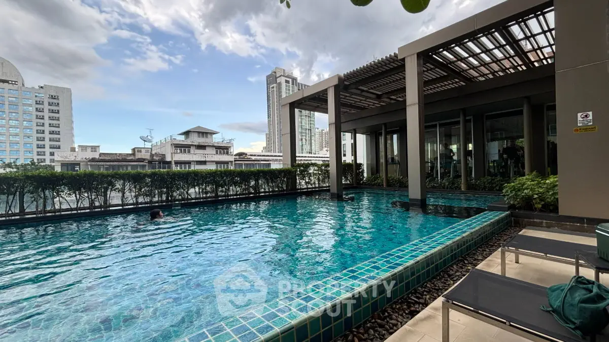 Luxurious rooftop pool with stunning city views and modern amenities in a high-rise building.
