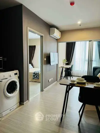 Modern apartment interior with open layout, featuring a cozy dining area and a glimpse of the bedroom.